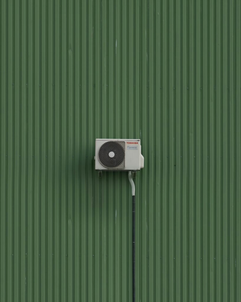 air conditioning unit on a green wall